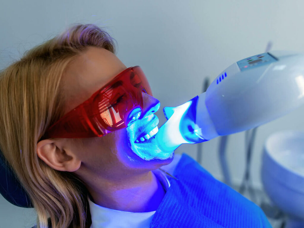patient wearing protective glasses while being treated with LED teeth whitening