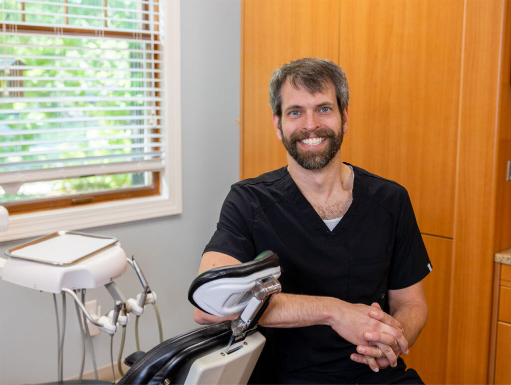 Dr. Ben leaning on a dental chair