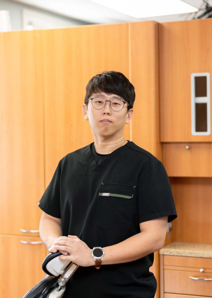 Dr. Jang leaning on a dental chair