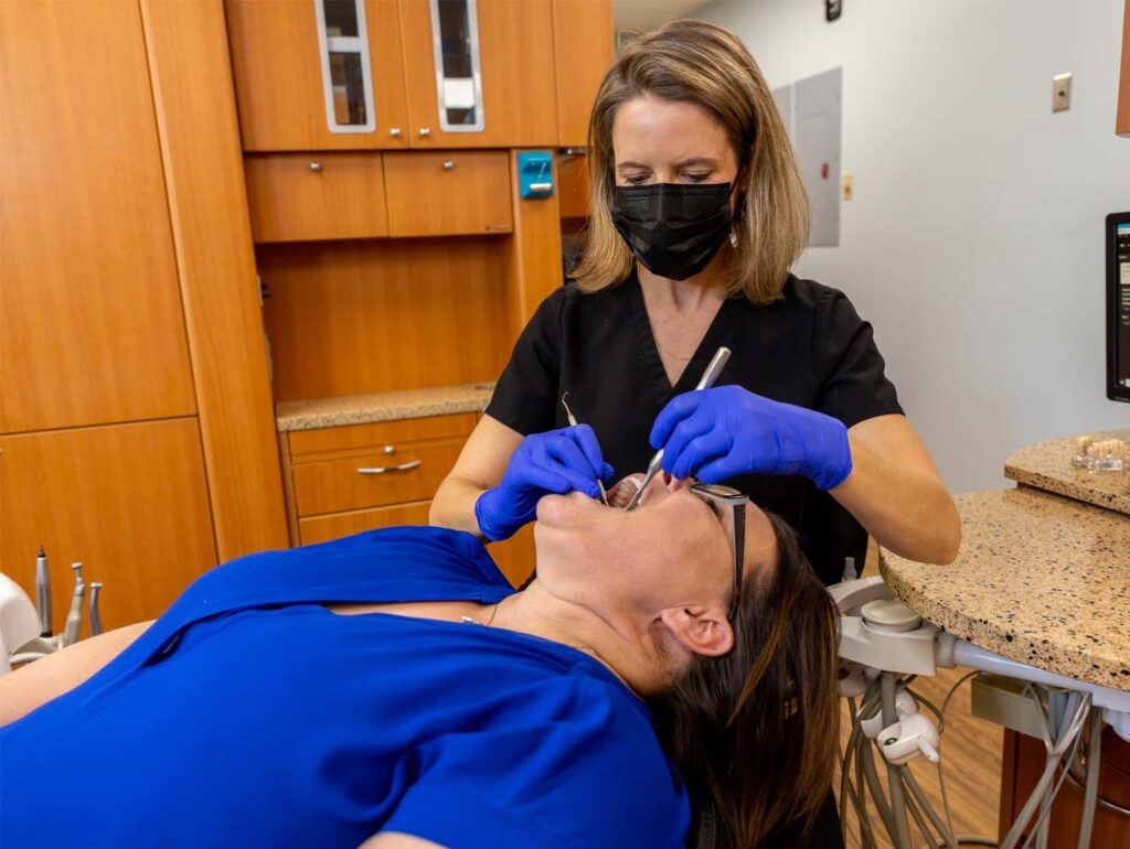 Dr. Liz working on a patient's teeth