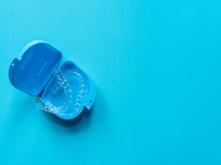 invisalign aligners in a blue case on a blue background